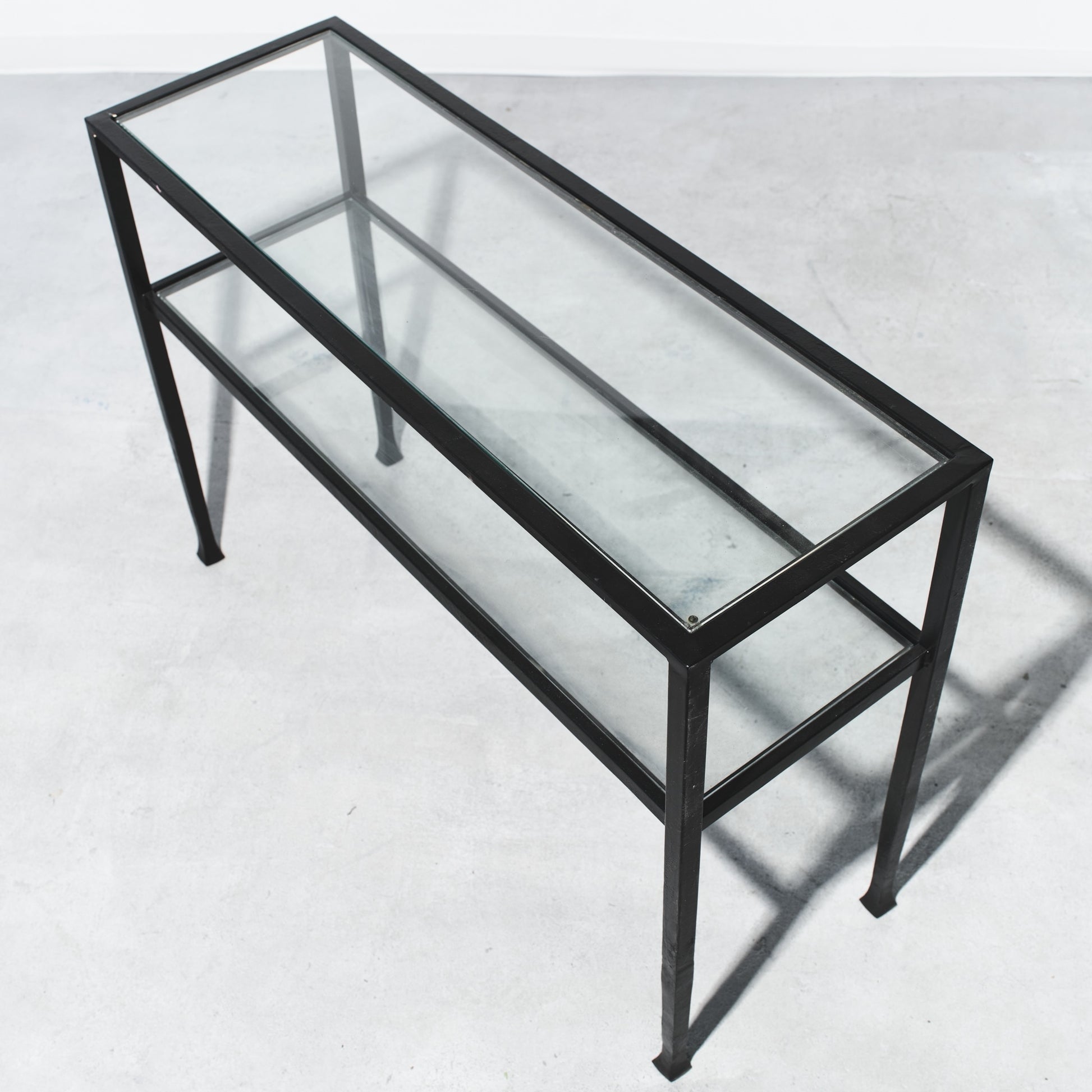 Glass display case with black metal frame on a white background