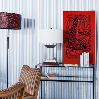 Living room with a red abstract painting, striped chair, and modern decor.