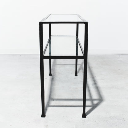 Glass display case with black metal frame on a white floor