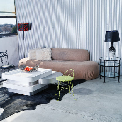 Modern living room with a brown sofa, white coffee table, and a yellow chair.