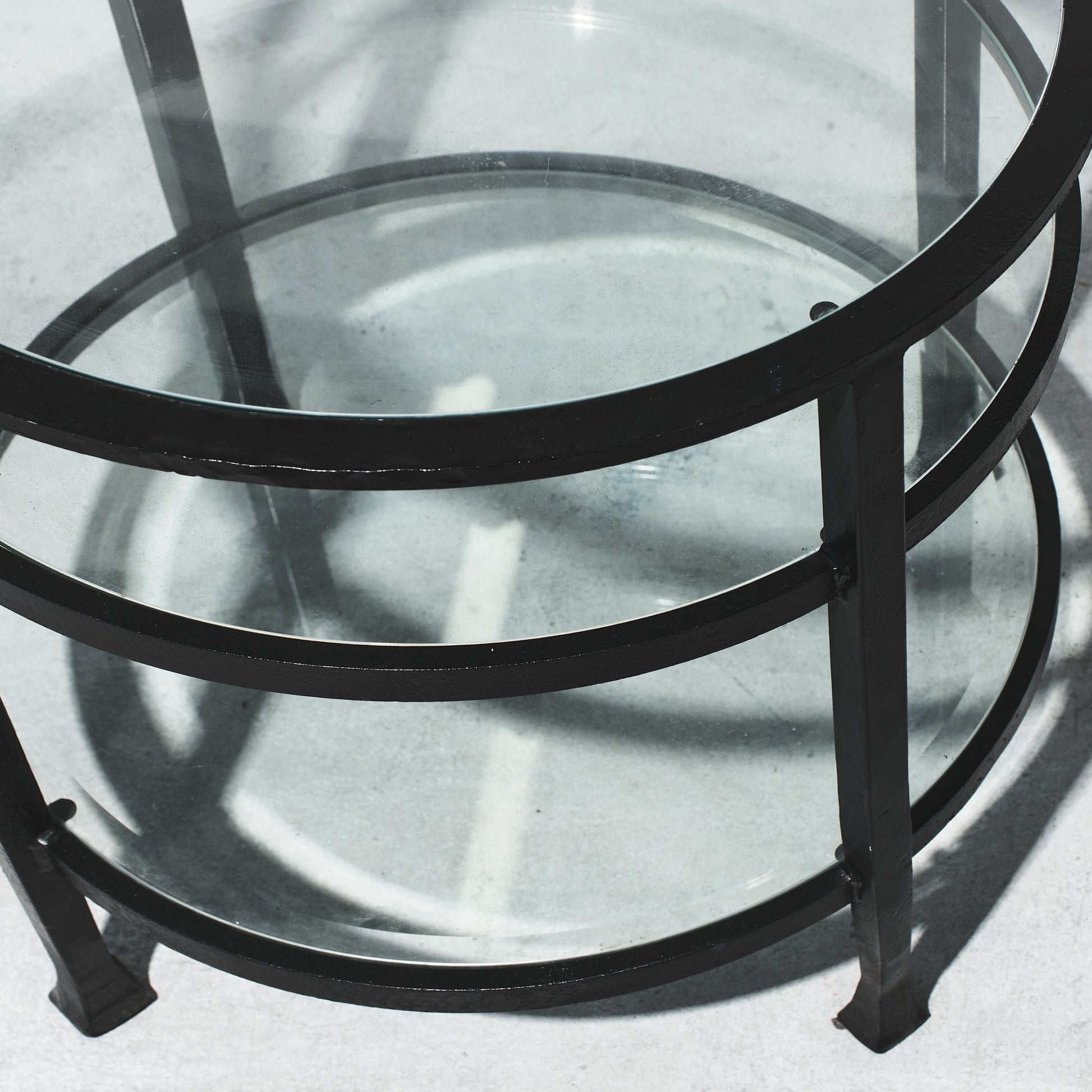 Glass table with black metal frame on a light gray background