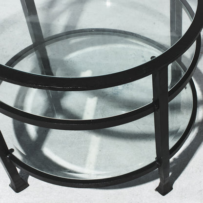 Glass table with black metal frame on a light gray background