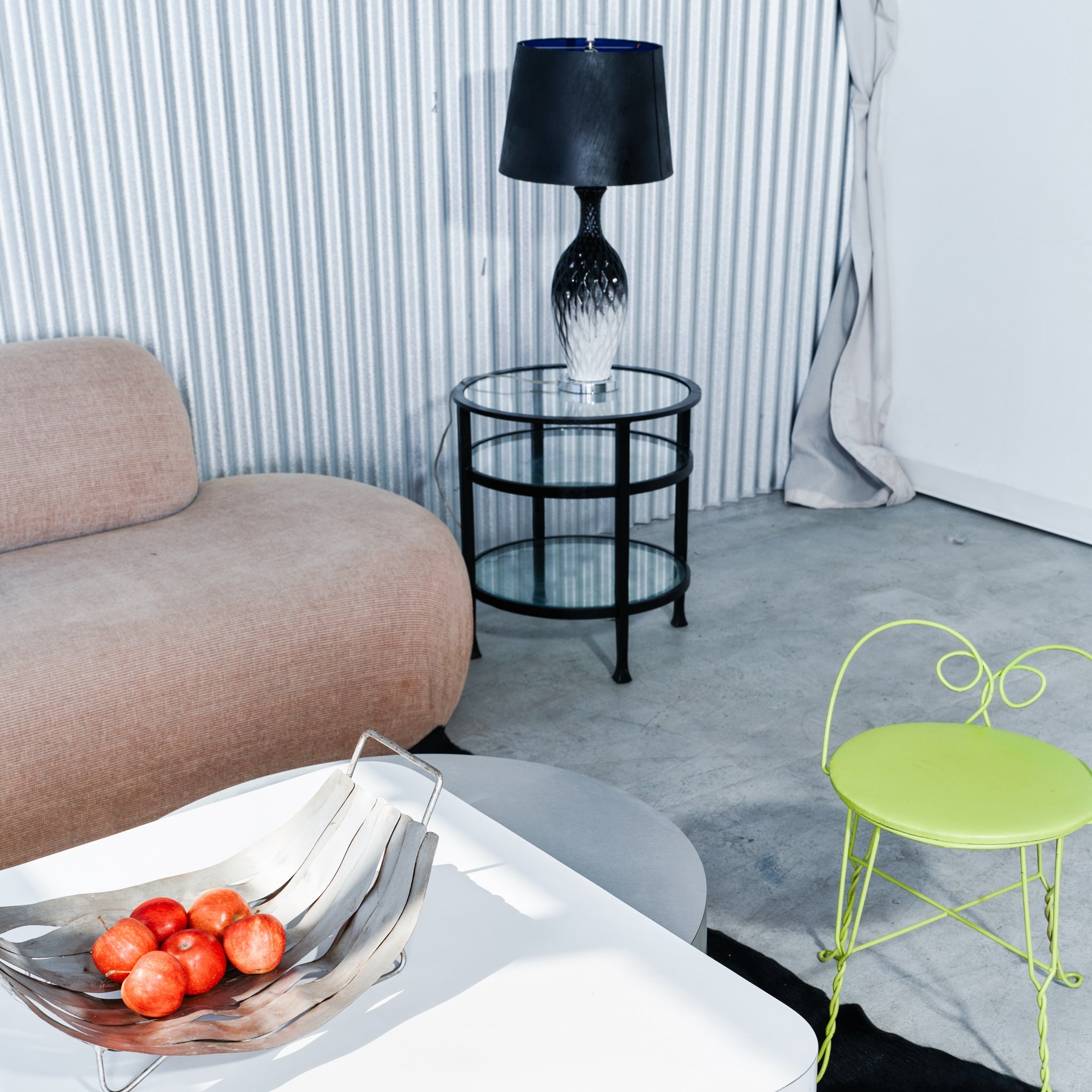 Modern living room with a beige sofa, green chair, and black lamp.