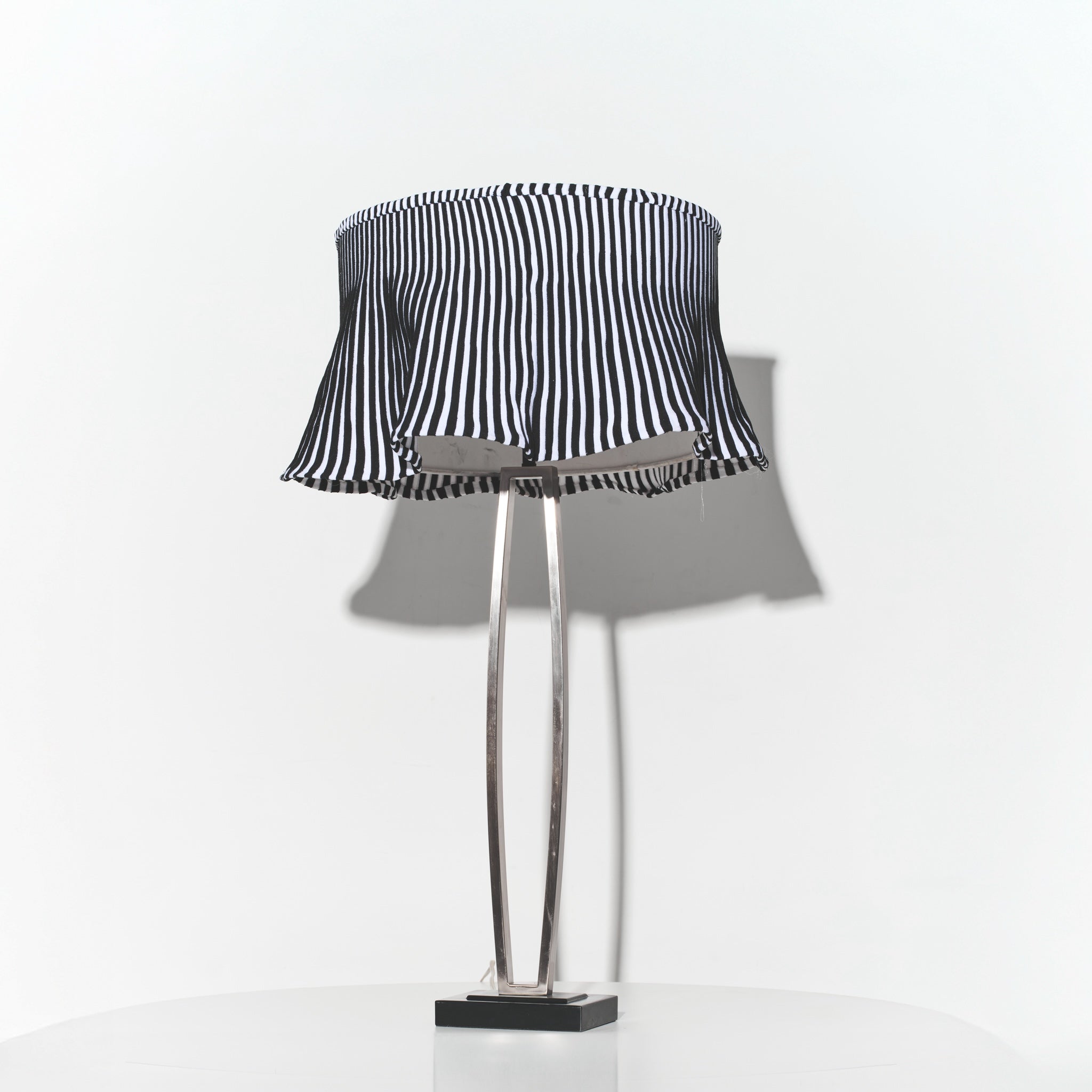 Table lamp with a black and white striped shade on a white background