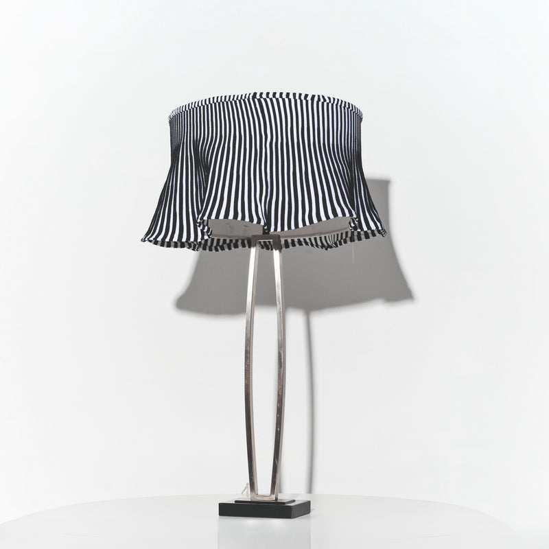 Table lamp with a black and white striped shade on a white background