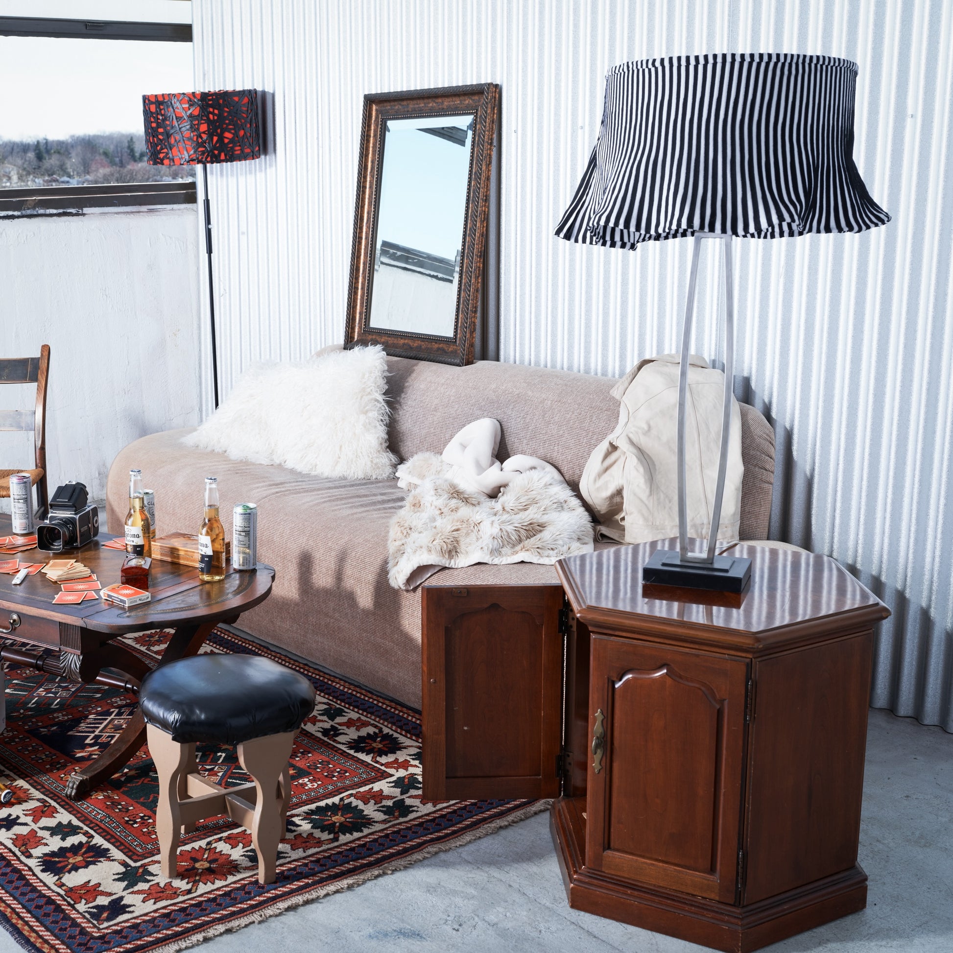 Living room with a beige sofa, wooden side table, and mirror.