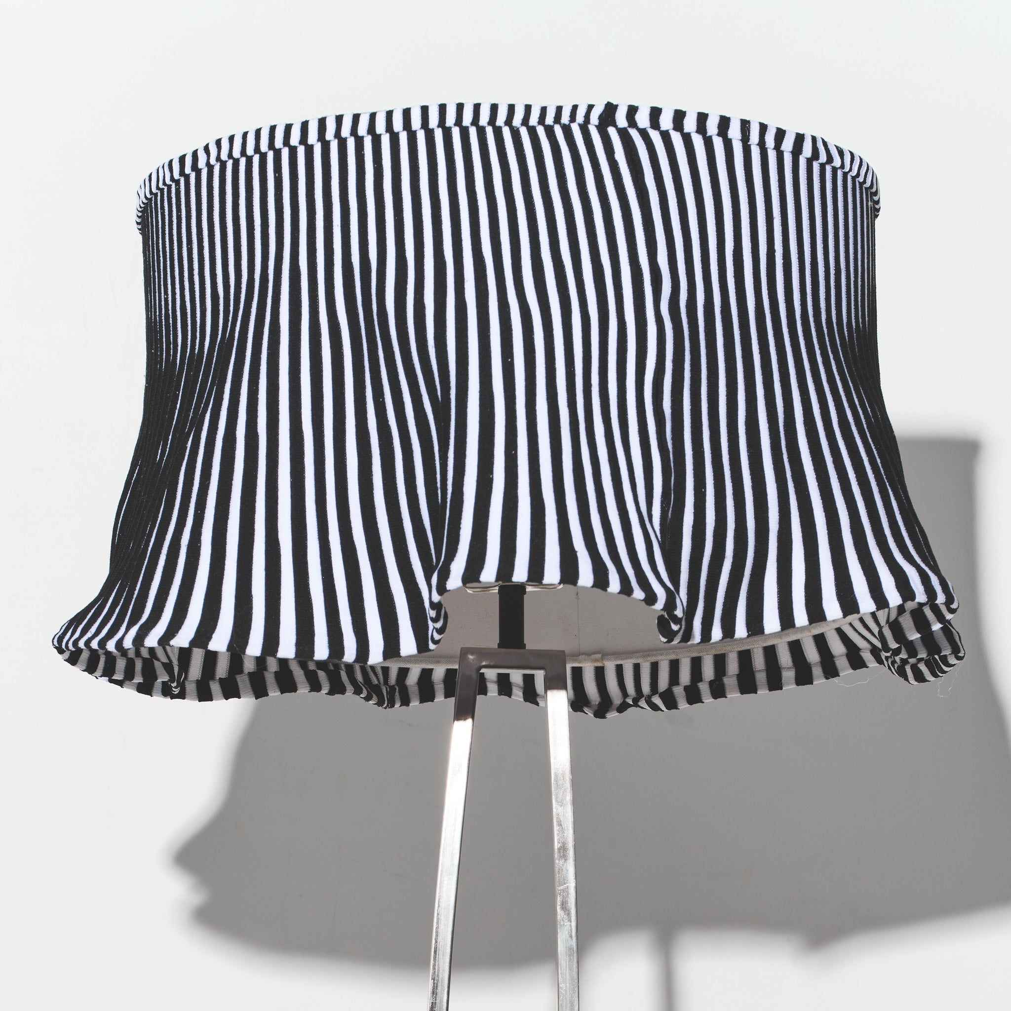 Black and white striped lampshade on a gray background