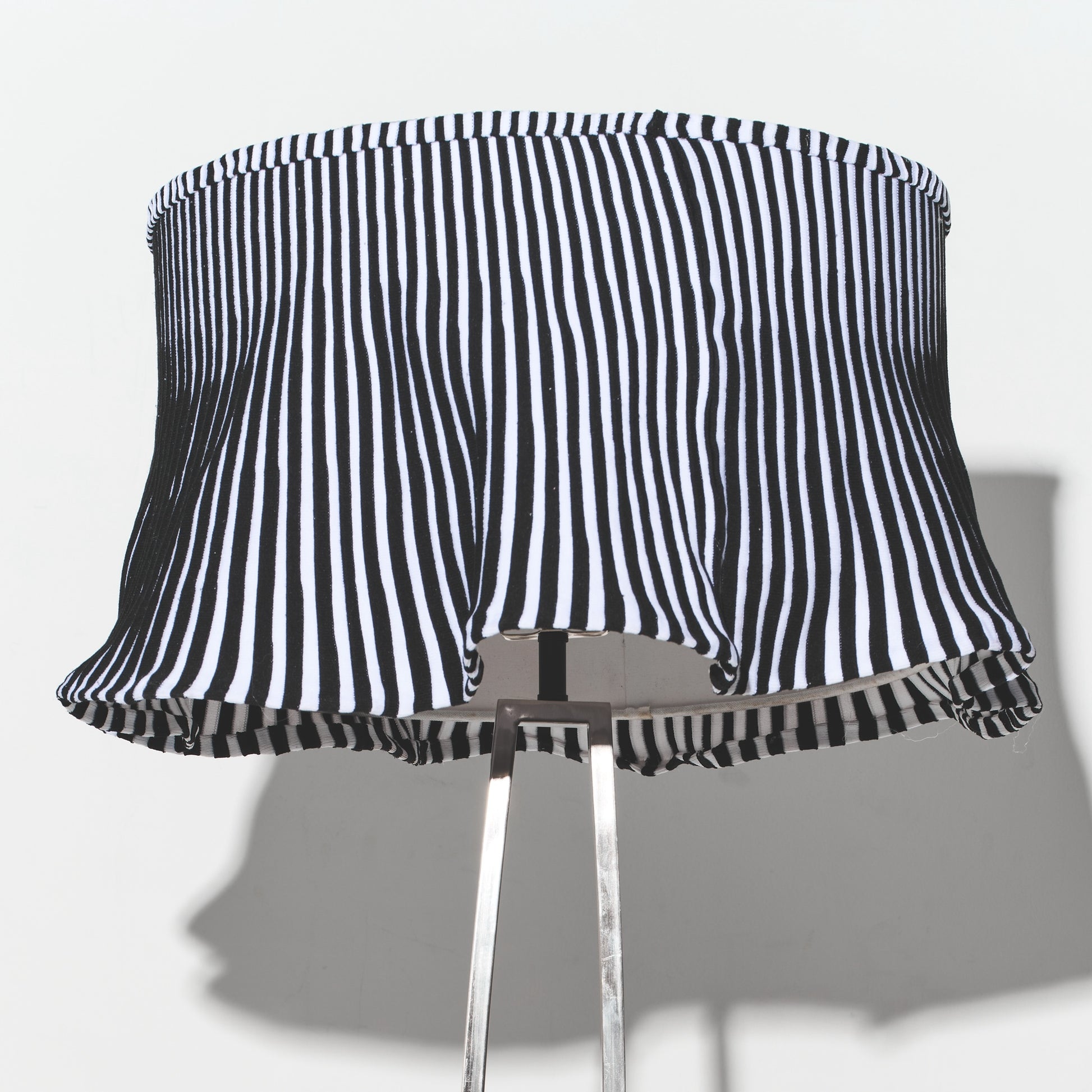 Black and white striped lampshade on a gray background