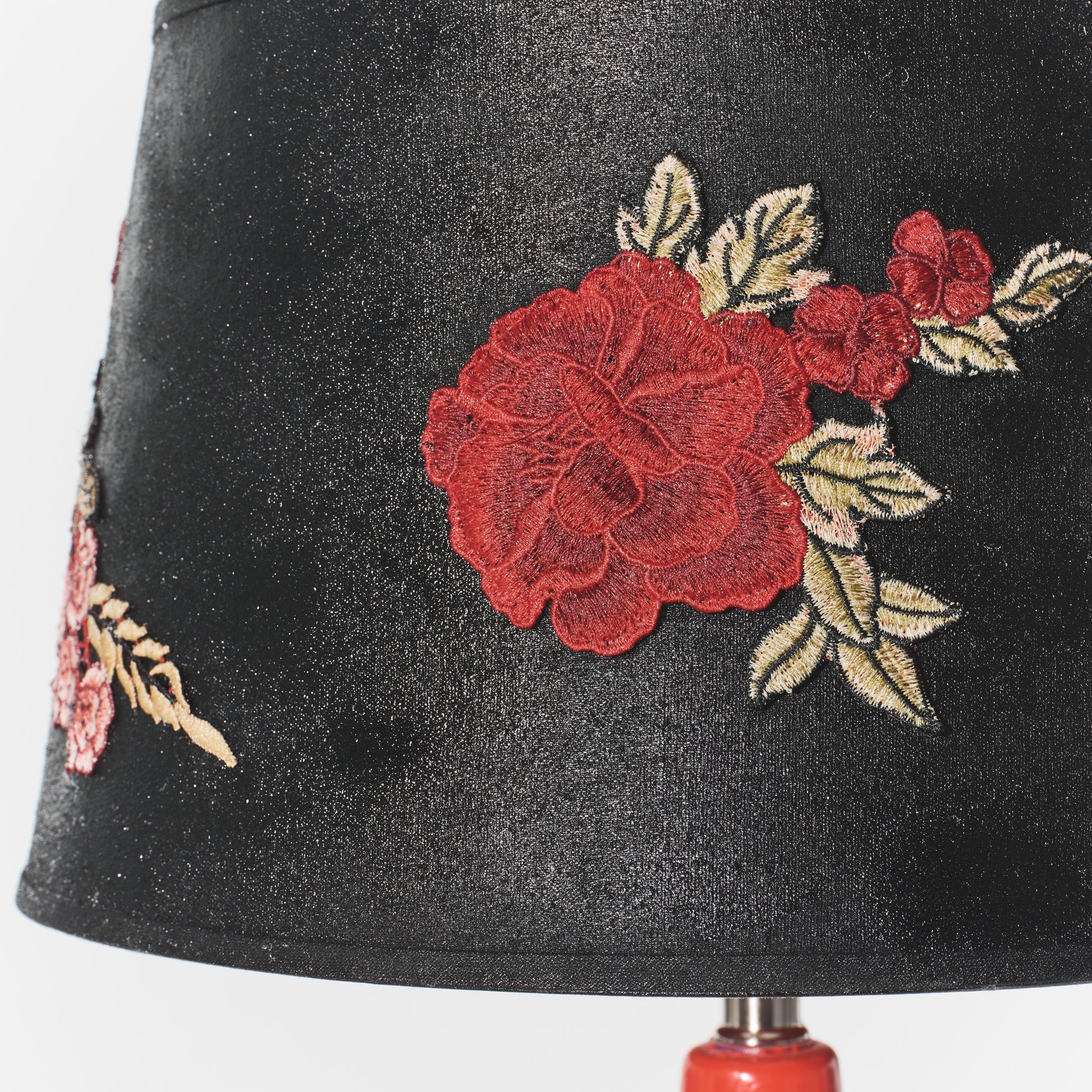 Black lampshade with red floral embroidery on a white background