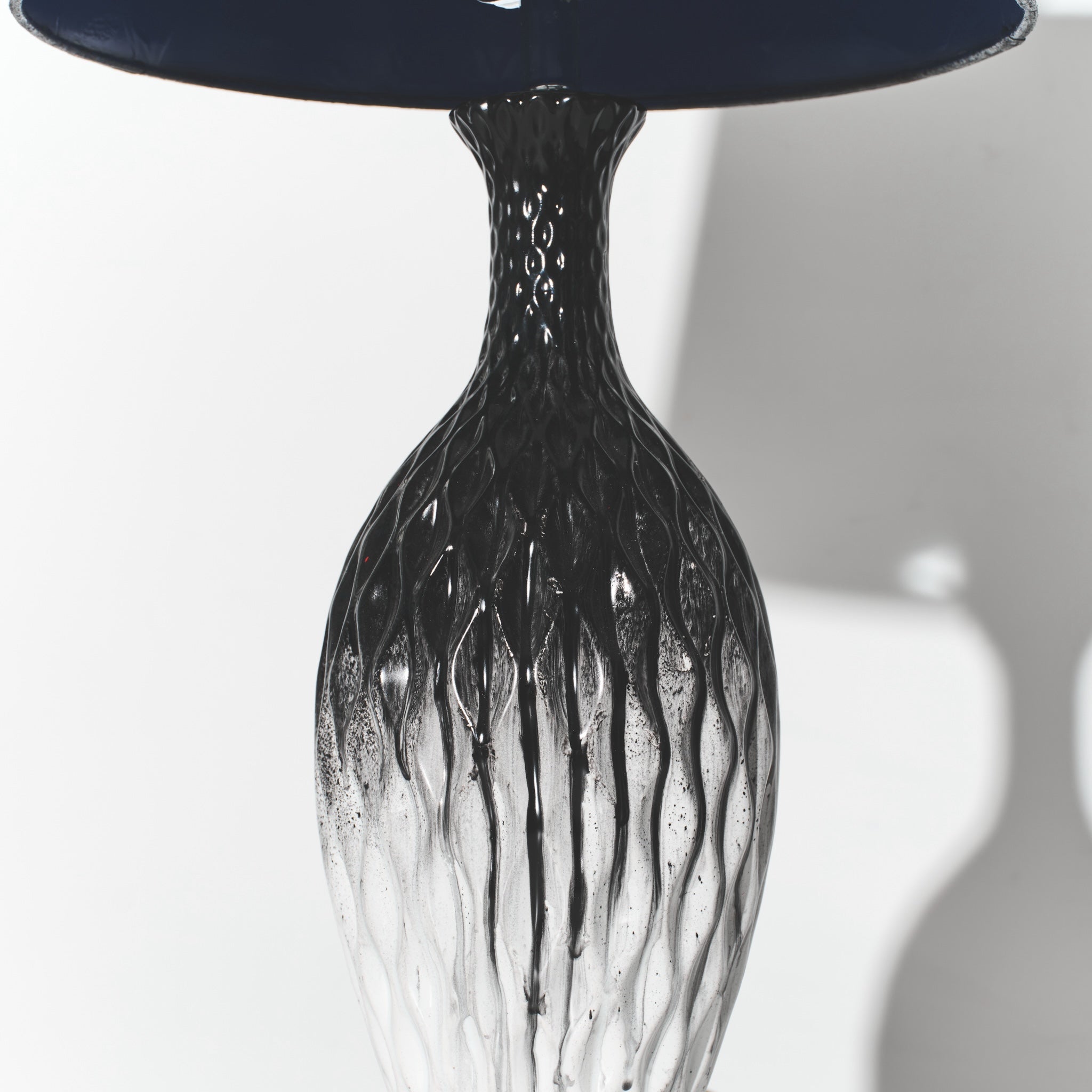 Black glass vase with textured design on a white background