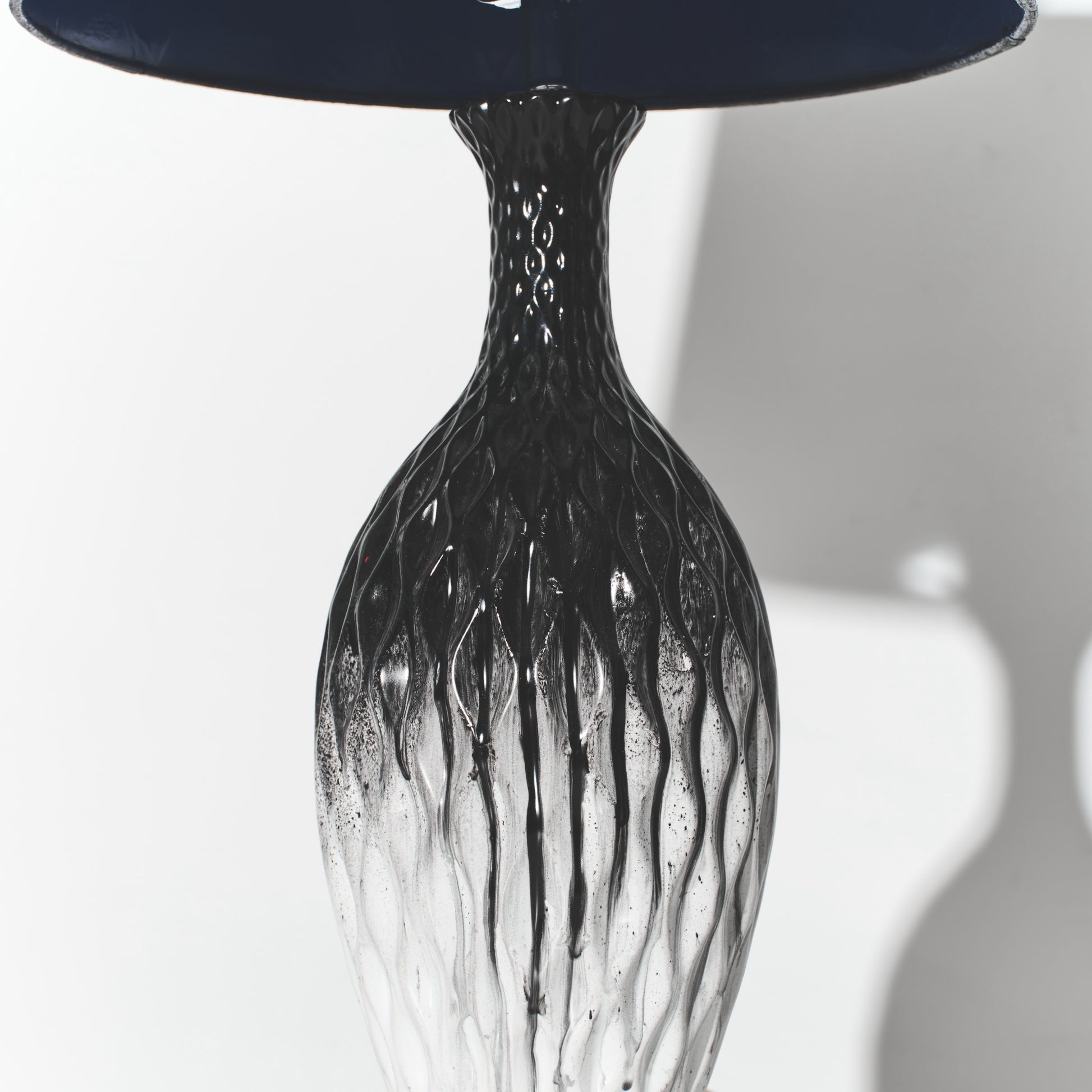 Black glass vase with textured design on a white background