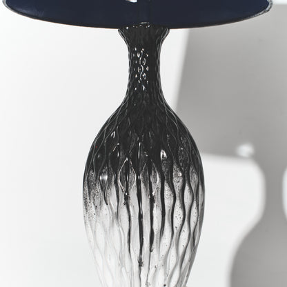 Black glass vase with textured design on a white background