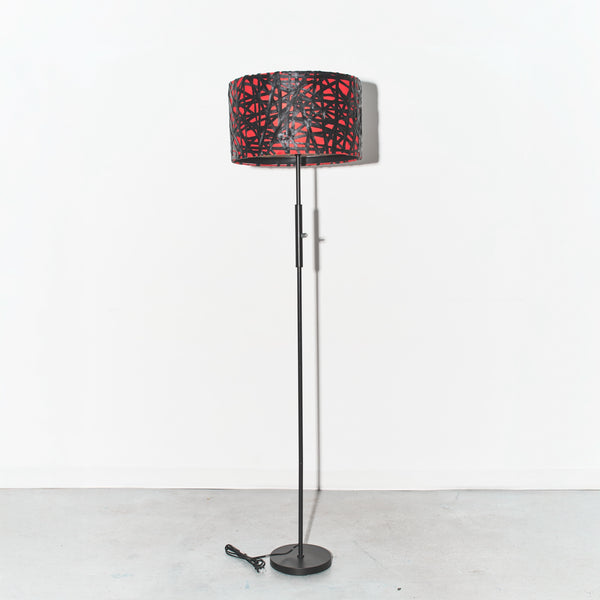 Floor lamp with a red and black patterned shade on a white background