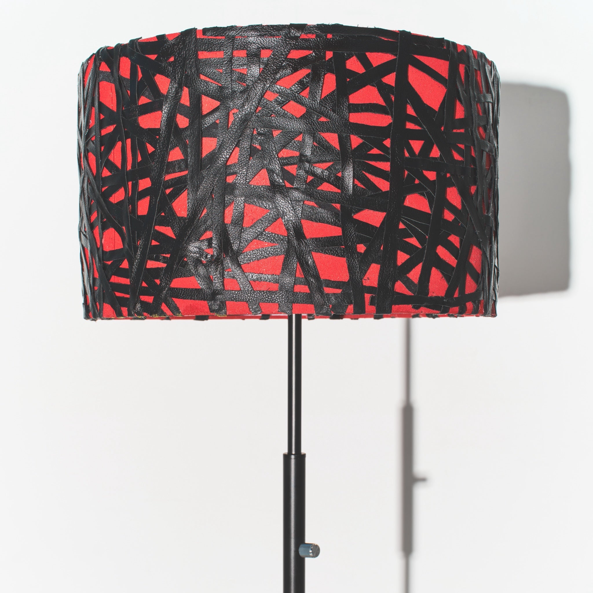 Lamp with a red and black patterned shade on a white background