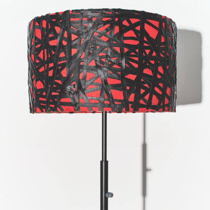 Lamp with a red and black patterned shade on a white background