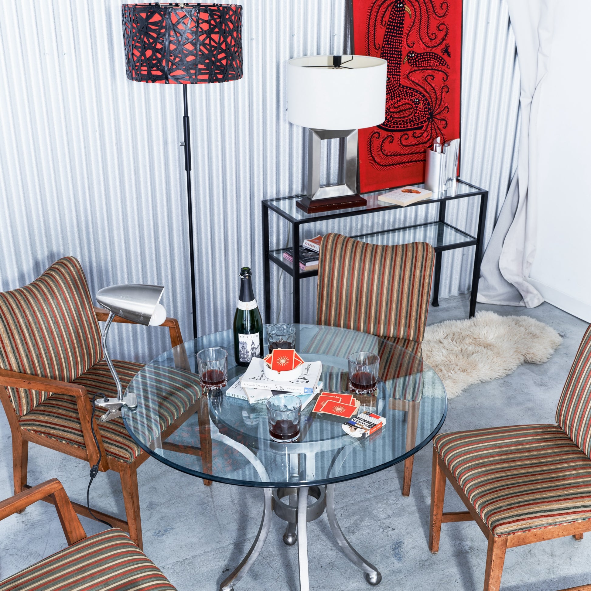Dining area with glass table, striped chairs, and decorative items.