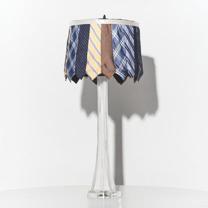 Lamp with a decorative shade made from ties on a white background