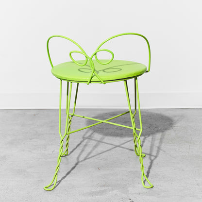 Neon green metal chair on a gray concrete floor with a white background