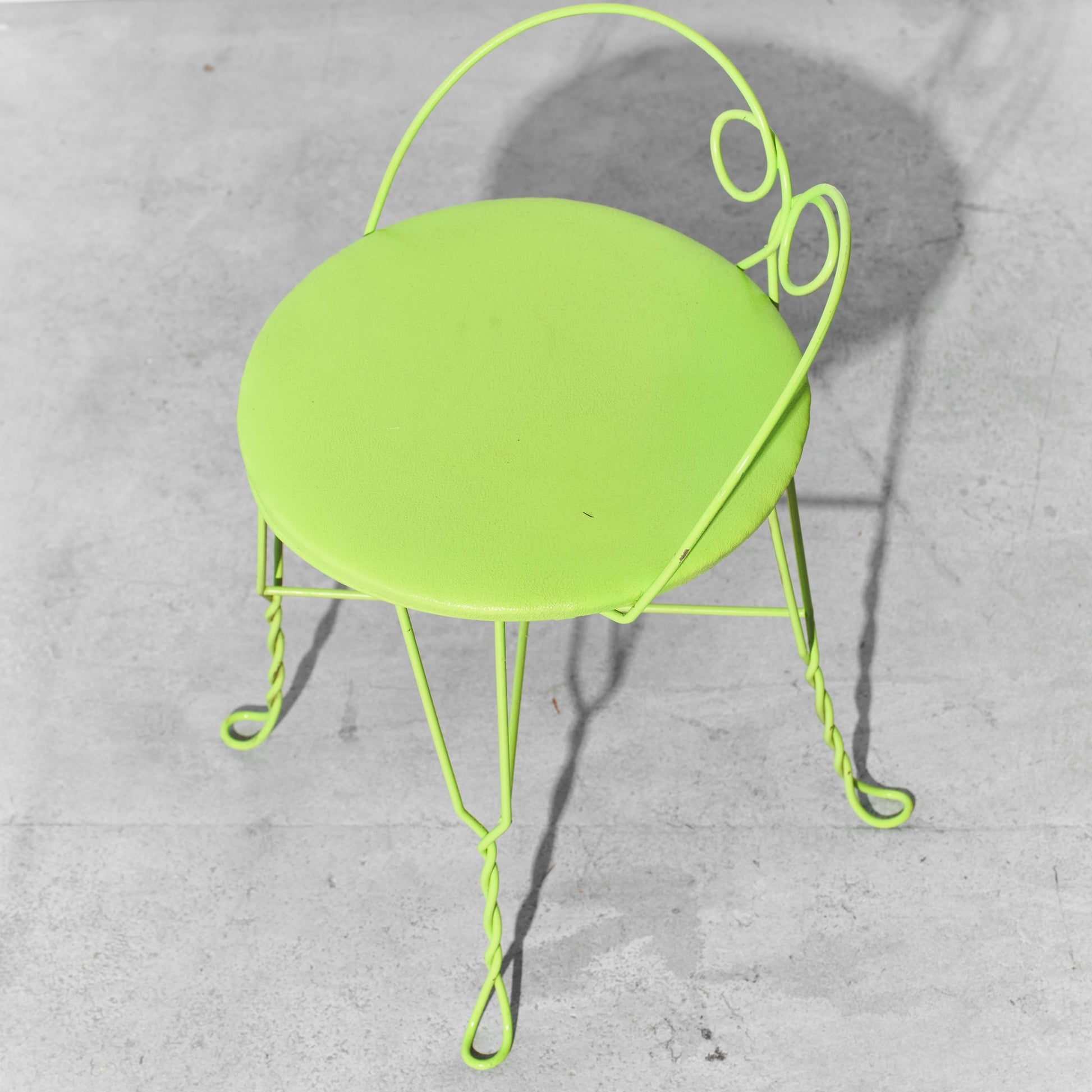 Neon green chair on a gray concrete floor