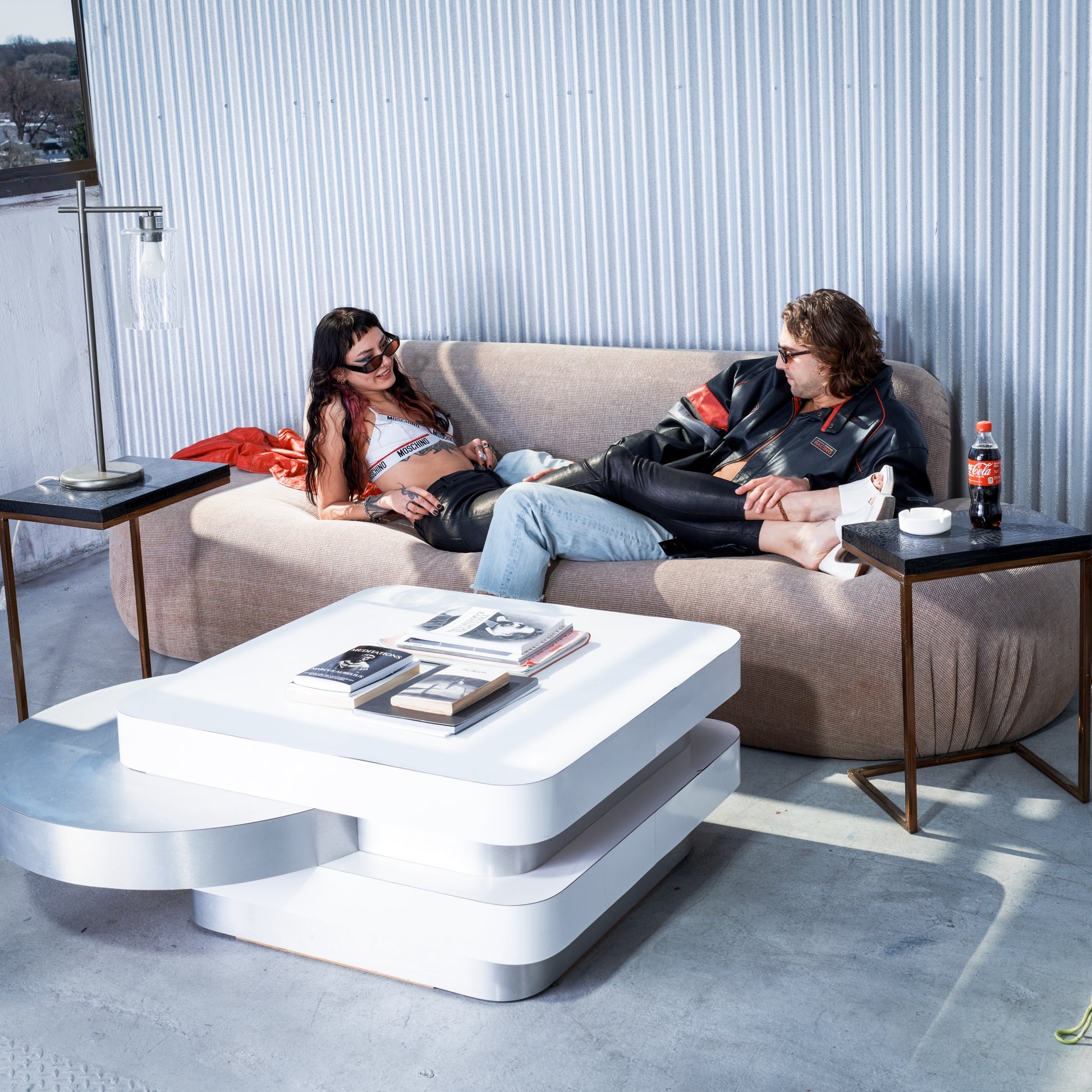 Two people sitting on a modern sofa with a white coffee table in a stylish room.