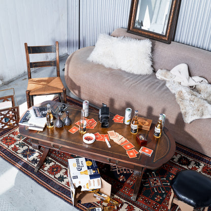 Living room with a coffee table full of drinks, cards, and a mirror on the wall.