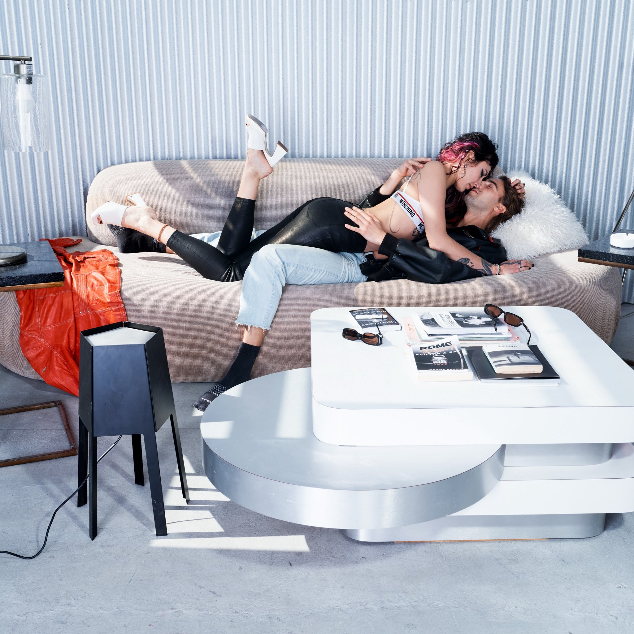 Two people embracing on a modern sofa in a stylish living room.